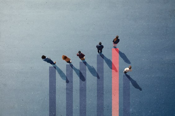 Group of employees photographed from above standing on graph.